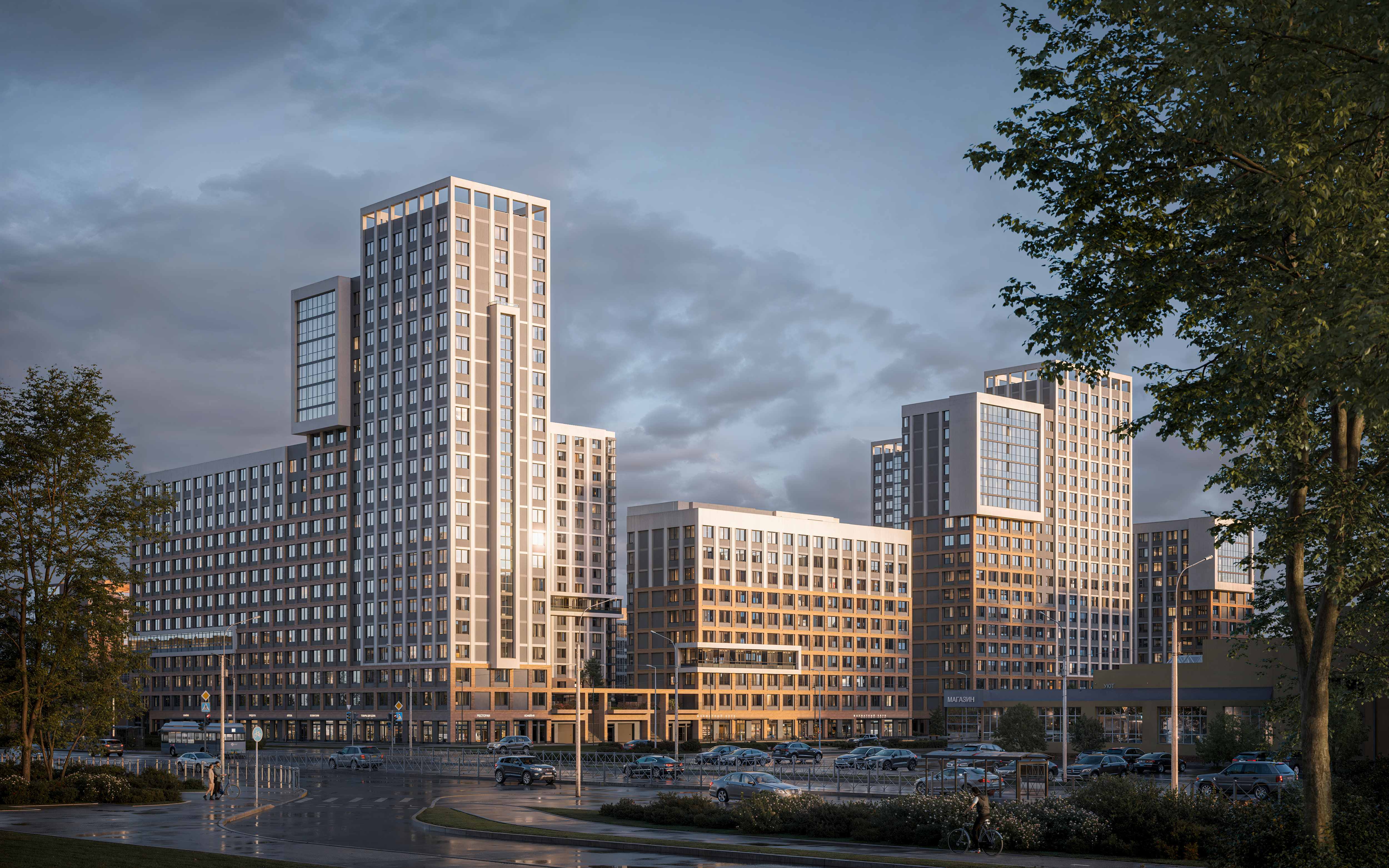 Вечерний вид на жилой комплекс с современной архитектурой и золотистым освещением фасадов