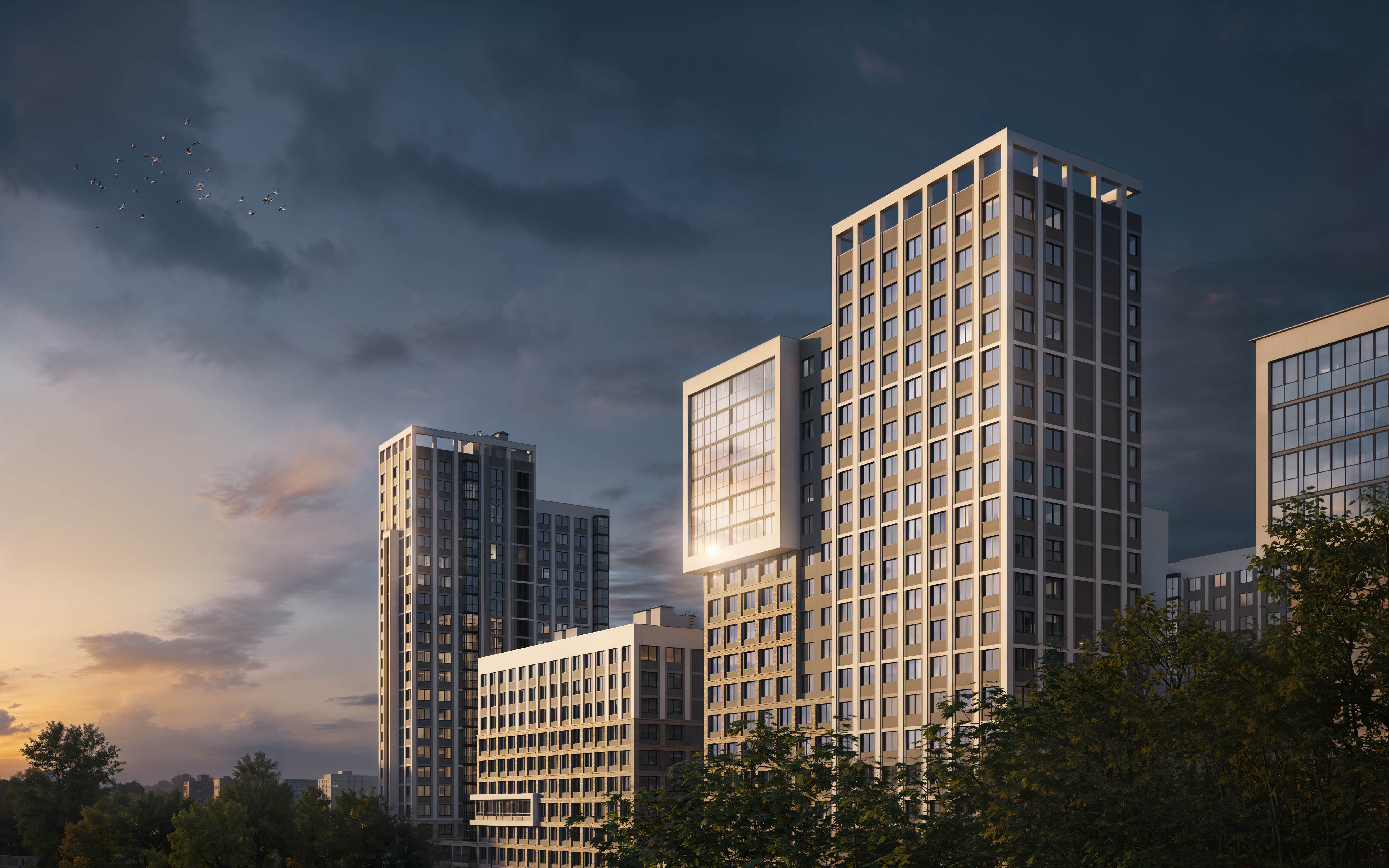 Жилые башни комплекса на фоне драматичного закатного неба с теплым освещением